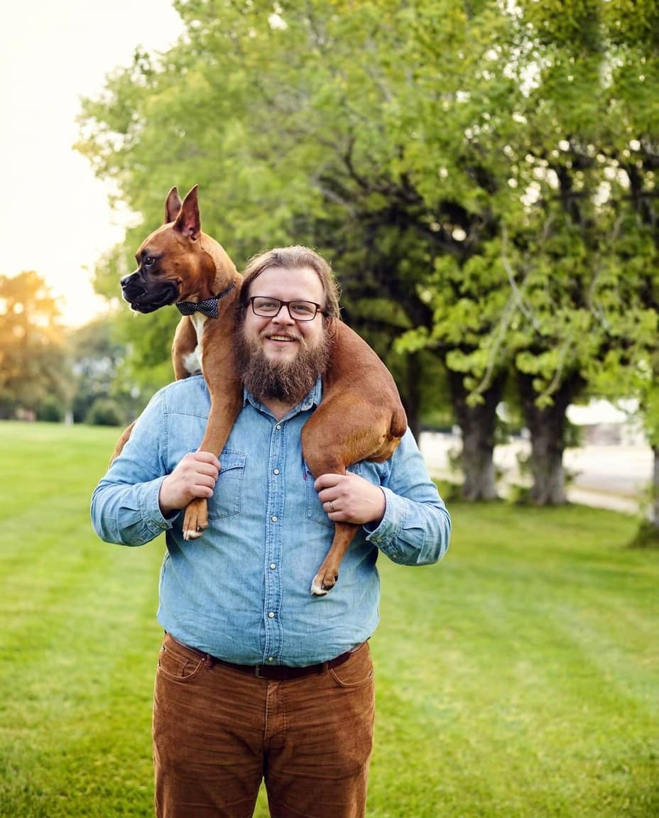 A man with his dog outdoors, a conversation-starting photo that works on Hinge